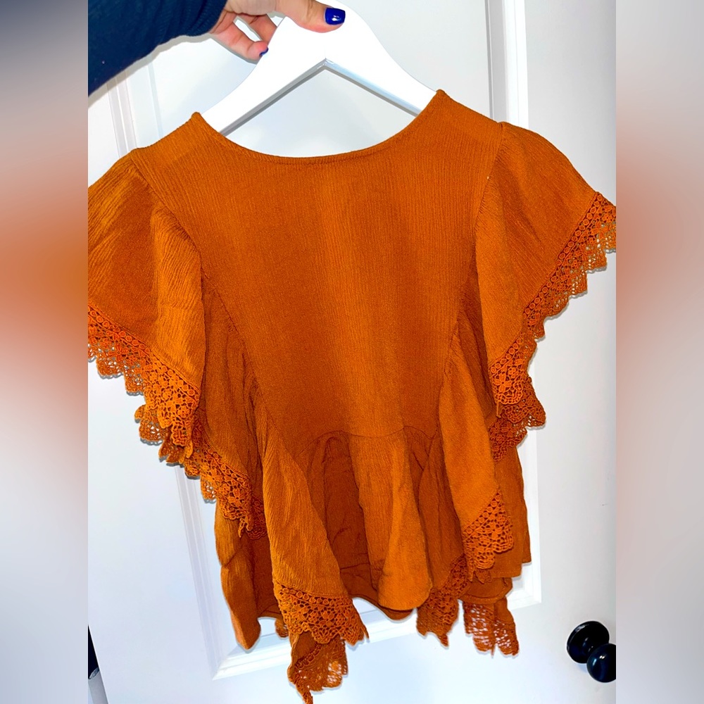 Orange blouse with ruffles on the sides. Super cute for the office or a date!